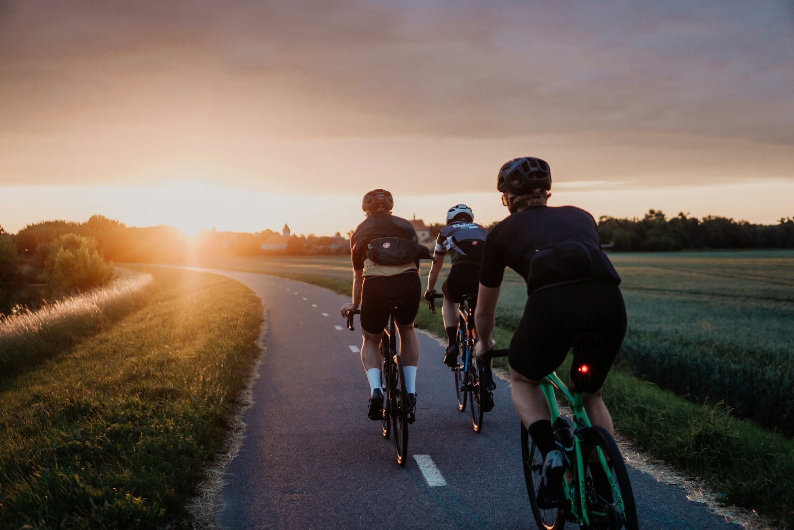 Group of men cycling up a canyon road at sunrise
